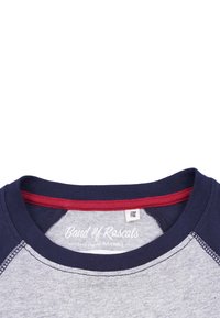 Marineblå og grå t-shirt med rund hals og kontrastfarvet rød inderside af kraven, med et mærke og broderede detaljer på halslinningen.