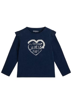 Granatowa koszulka z długim rękawem dla małego dziecka, z falbankami na ramionach i wzorem serca z napisem "forever Guess 1981" wykonanym z cekinów na przodzie.