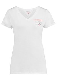 Camiseta de algodón blanca de manga corta con cuello en V, que presenta un texto gráfico en rosa y negro "TOMMY JEANS 1985" en la parte frontal.