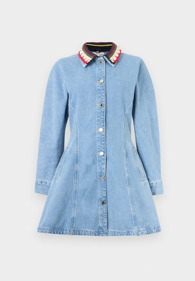 Φόρεμα από ανοιχτό μπλε τζιν με μακριά μανίκια, κουμπιά στο μπροστινό μέρος και πολύχρωμο πλεκτό γιακά με ρίγες σε κόκκινο, λευκό και πράσινο.