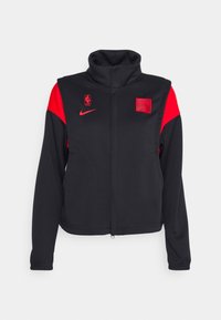 Veste de sport zippée noire et rouge avec col montant, logos NBA et Nike, et un écusson des Chicago Bulls sur la poitrine.
