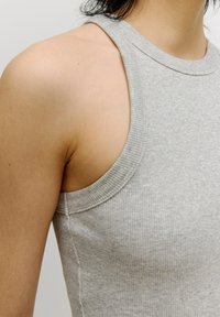 Grauer, gerippter Tank-Top mit weitem Ausschnitt und ärmellosem Design. Verfügt über eine enganliegende Passform und strukturierten Stoff. Nahtdetails sind an der Seite sichtbar.