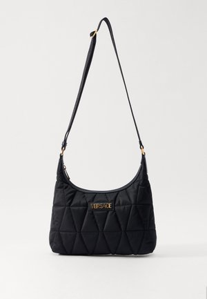 Looduslike musta nailonist õlarihmaga kott, millel on kuldne logo plaat, õhuke rihm ja ümar kuju. Omab diagonaalitriibulist kuldset nahkstiili.