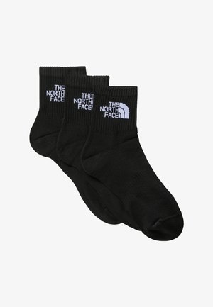 Trys juodų kulkšninių kojinių poros, pagamintų iš lygaus mezginio audinio, su balta "The North Face" logotipo projekcija ant krašto.