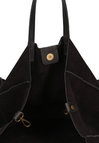 Borsa tote nera in suede con dettagli in pelle, chiusura a scatto superiore e finiture in ottone dorato. L'interno aperto presenta una texture liscia e una fodera morbida.
