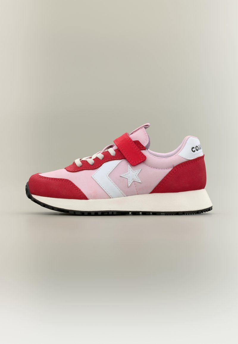 Ροζ και κόκκινο χαμηλό αθλητικό παπούτσι με λογότυπο λευκό αστέρι, λουράκι με βέλκρο, κορδόνια και μαύρη σόλα σε ουδέτερο φόντο.