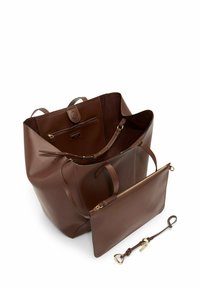 Brown leather tote bag with detachable zip pouch and matching leather keychain with gold-toned hardware on white background.