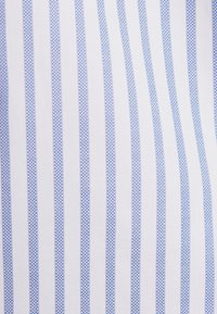 Witte stof met verticale lichtblauwe strepen, voorzien van een fijn gestructureerd patroon. Het ontwerp is overal in het materiaal consistent.