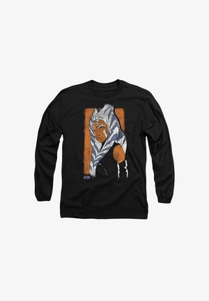 Schwarzes Langarmshirt mit einer grafischen Illustration auf orangefarbenem Hintergrund, die einen Charakter mit weißen und blauen Kopftails und Rüstung zeigt.