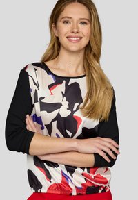 Schwarz- und mehrfarbiges abstraktes Musteroberteil mit Dreiviertelärmeln, elastischem Saum, aus glattem, leichtem Stoff gefertigt.