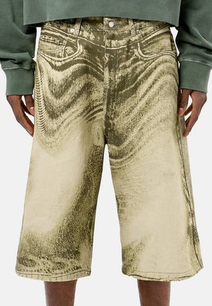 KnÄxlånga shorts i en blekt khaki färg med abstrakta svarta mönster, med fem fickor och metallknappstängningar. Denim material.