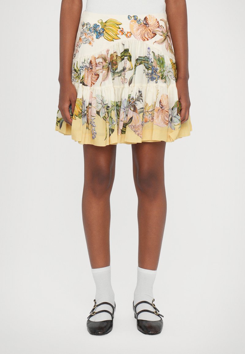 Floral-patterned pleated skirt in cream and soft yellow tones, with vibrant flowers and greenery. Accented with a fitted waistband.