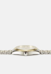 Montre en métal argenté et doré avec un boîtier circulaire, un cadran blanc et un bracelet à maillons. Comprend une couronne latérale saillante.