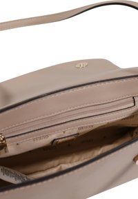 Borsa a tracolla in pelle beige con una sola tracolla, hardware dorato, tasca con zip e interno in satin con un motivo logo ripetuto.