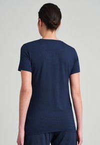 Marinblå kortärmad t-shirt med rundad halsringning och slät yta, med en avslappnad passform och något längre bakkant.