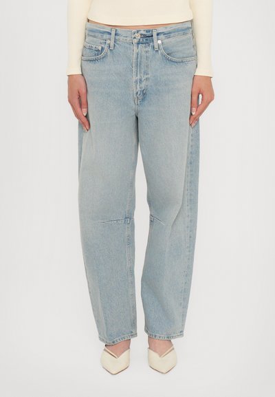 Jean bleu clair, ample, en denim avec un délavage légèrement usé. Comprend un design standard à cinq poches et des détails de couture visibles.