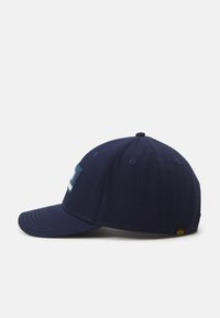Sötétkék baseball sapka ívelt karimával, texturált logóval az elülső részen és szellőzőlyukakkal az oldalán.