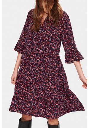 Granatowa sukienka w kwiaty z krótkimi falbanianymi rękawami, z czerwonymi i niebieskimi kwiatami, o warstwowym kroju, wykonana z lekkiego materiału.