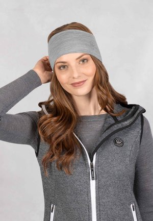 Bandeau en tricot gris avec un tissu texturé, porté par une personne dans un gilet zippé gris avec des accents noirs et un logo circulaire près de la fermeture éclair.