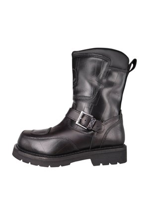 Botte de moto en cuir noir avec une hauteur mi-mollet, surface texturée et une sangle à boucle en argent sur le côté. Semelle en caoutchouc durable.