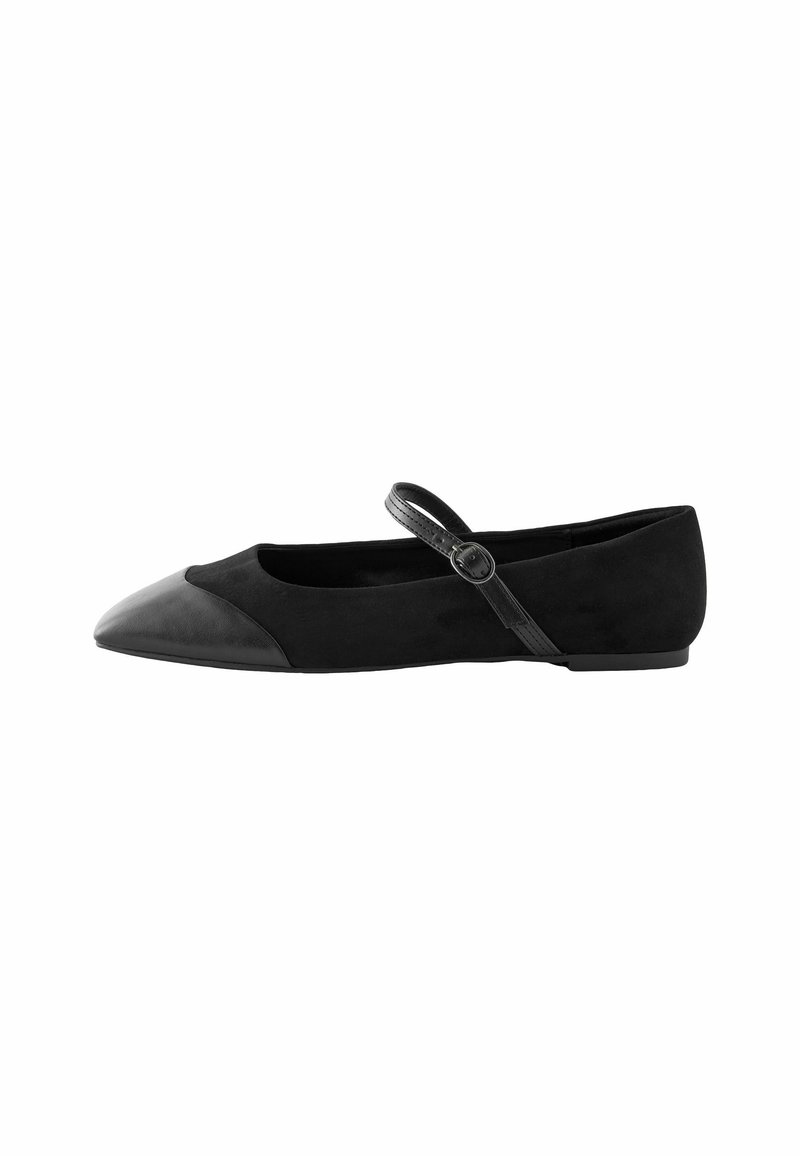 Chaussure Mary Jane plate noire avec pointe en cuir pointue et bride ajustable à boucle sur fond blanc.
