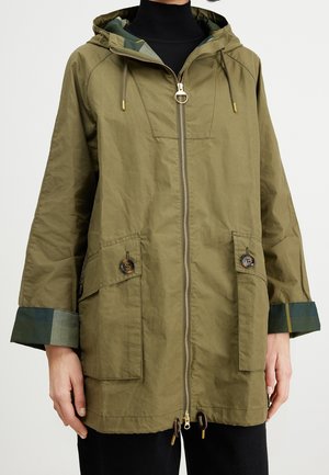 Oliwkowa zielona kurtka z kapturem, z zamkiem z przodu, kieszeniami na klapki zapinanymi na guziki oraz podwiniętymi mankietami odsłaniającymi ciemnozieloną kratkę podszewki.