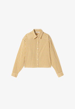 Chemise à manches longues boutonnée à carreaux jaunes et blancs avec col, ourlet raccourci et coupe classique, posée à plat sur fond blanc.