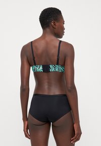 Zwarte bikini-set met een turquoise en zwarte zebra-strepen achterkant. Dunne verstelbare bandjes en een haak-en-oogsluiting op de rug.