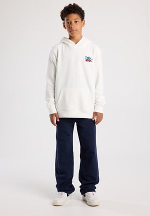 Witte hoodie met voorzak, met een kleurrafiek ontwerp; gecombineerd met marineblauwe broek en witte Sneakers. Gladde textuur, casual ontwerp.