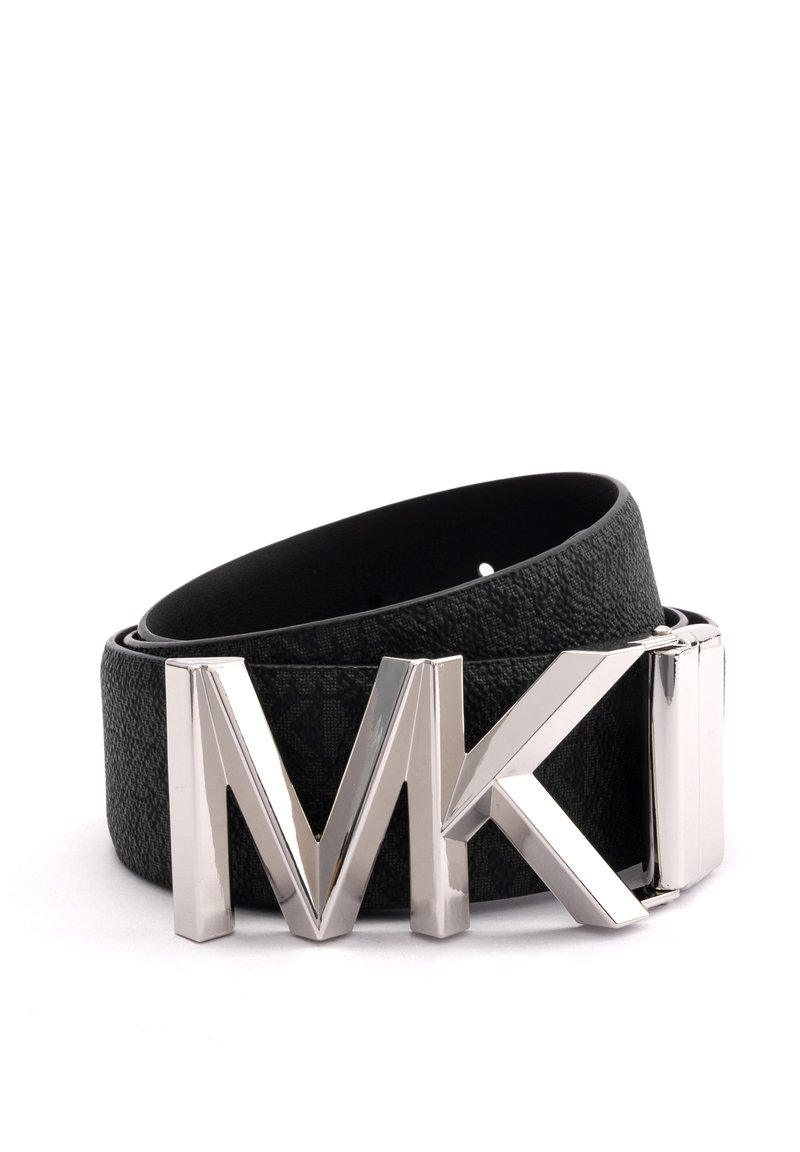 Ce ceinturon en cuir noir présente une finition texturée, avec une grande boucle métallique argentée en forme de "MK". Design à sangle fine.