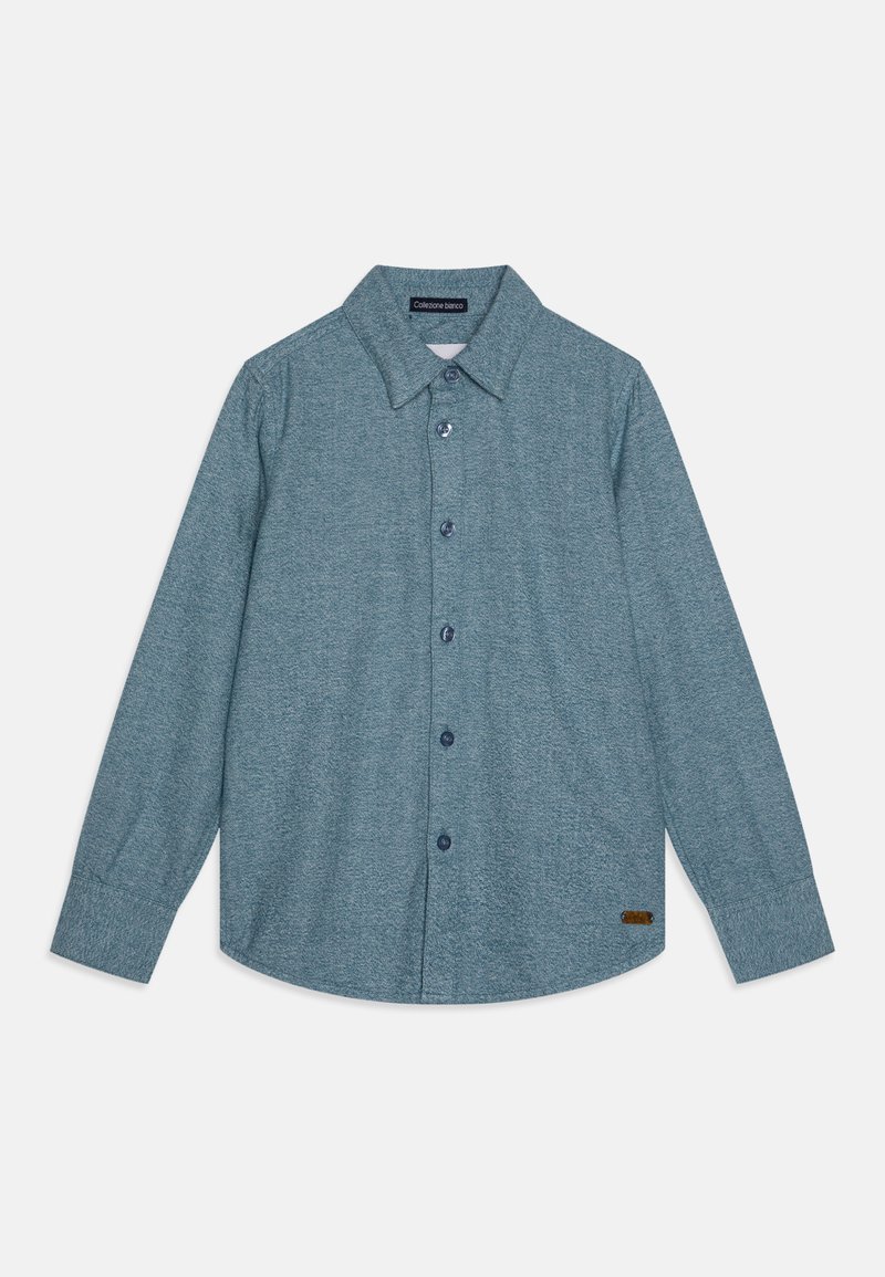 Svijetlosmeđa dugosvečka košulja s dugim rukavima izrađena od teksturirane tkanine. Ima klasični ovratnik, šest dugmadi i malu smeđu oznaku na rubu.