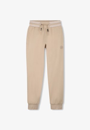 Pantalon de survêtement beige avec taille à cordon, bande élastique rayée et jambes fuselées. Présente un petit logo sur la cuisse gauche. Texture de tissu douce.