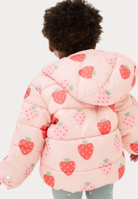 Giacca a vento rosa con cappuccio, caratterizzata da un motivo a fragole rosse e verdi. Il materiale sembra gonfio con sezioni trapuntate.
