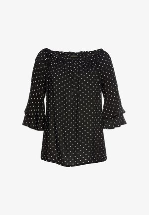 Zwarte off-the-shoulder top met witte stippen, voorzien van ruches op de mouwen en een gathered halslijn voor extra textuur.