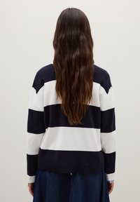 Navy- und weiß gestreifter Pullover mit lockerem Schnitt, gestrickter Textur, geripptem Saum und überschnittenen Schultern, von hinten gesehen.