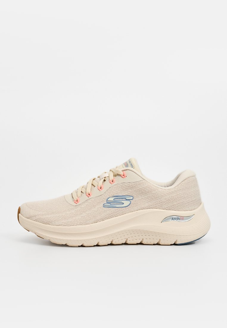 Zapatilla deportiva beige con parte superior de tejido texturizado, cordones rosa claro, entresuela blanca y logo azul. Cuenta con una suela acolchada para mayor comodidad.