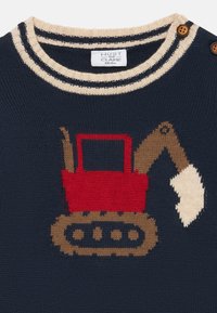 Pull en maille marine avec un design d'excavateur rouge. Le col rond présente des rayures crème et marine avec des détails de boutons marron.