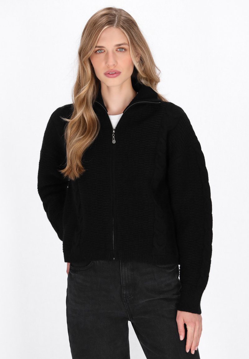 Maglione zip-up nero con un design a costine testurizzate e orlo a coste. Presenta un colletto rialzato e maniche lunghe.