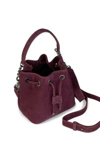 Suède emmermand tas in diep bordeauxrood met verstelbare schouderriem, trekkoordsluiting en metalen hardwareaccenten. Zachte textuur.