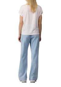 Lichtroze en witte gestreepte t-shirt met korte mouwen gecombineerd met lichtblauwe, licht vervaagde spitsbroek met een relaxte pasvorm.