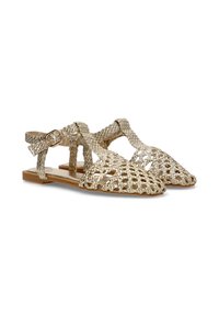 Sandalias planas trenzadas en oro con un diseño abierto, que cuentan con un cierre de hebilla y un patrón tejido texturizado sobre una suela clara.