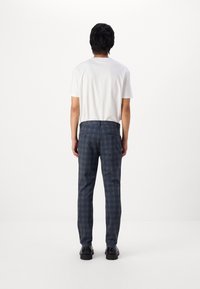 Pantalones de cuadros azul marino con un corte ajustado. Están confeccionados en una tela suave, con dos bolsillos traseros y una cinturilla estándar.