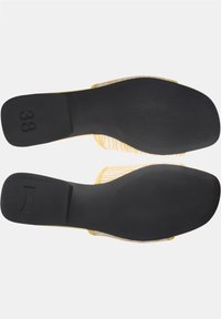 Yellow slip-on shoes with striped fabric upper and black rubber soles. Size 38 marked on the heel. Texture is smooth with a patterned grip.