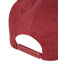 Rote Mütze aus strukturiertem Stoff mit einem verstellbaren Kunststoffband und Lüftungslöchern auf der Rückseite.