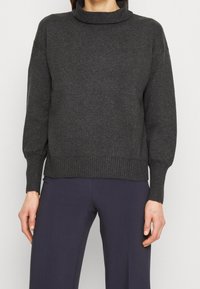 Pull-over en tricot gris foncé avec col montant, poignets et ourlet côtelés, coupe décontractée et manches mi-longues. Convient pour une tenue décontractée.
