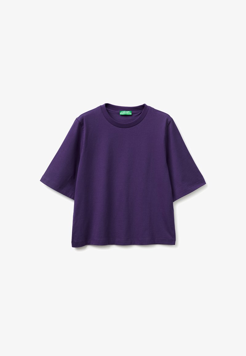 Camiseta morada de manga corta y cuello redondo, de corte holgado, mostrada extendida sobre un fondo blanco.