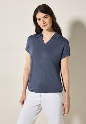 Polo a maniche corte blu navy con colletto, in tessuto leggero, dotato di una cerniera anteriore e maniche arrotolate. Design semplice e pulito con una vestibilità rilassata.