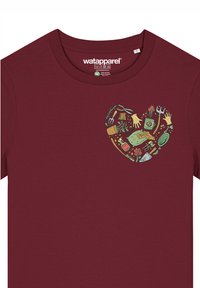 T-shirt bordeaux avec un graphique en forme de cœur composé d'outils de jardinage, de légumes et de mains, avec une texture douce et lisse.