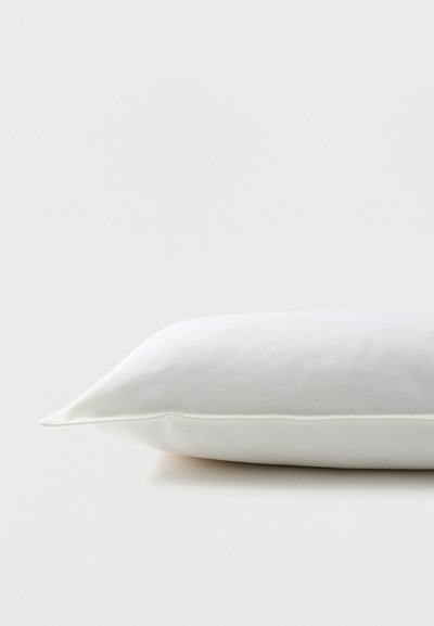 Απλό λευκό ορθογώνιο μαξιλάρι που βρίσκεται επίπεδο πάνω σε λευκή επιφάνεια, με ορατή απαλή υφή υφάσματος.