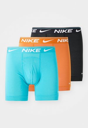 Zestaw trzech bokserów Nike: turkusowy, pomarańczowy i czarny. Każdy z nich posiada elastyczny pas z logo i dopasowany krój, wykonany z gładkiego, elastycznego materiału.